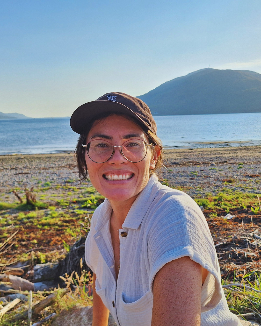 Amanda Chu sitting by a lake with mountains in the background