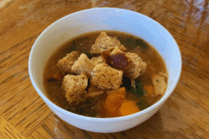 A bowl of Instant Pot Turkey Tuscan Kale Soup topped with homemade Sourdough Croutons