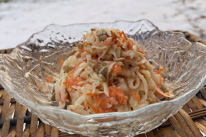 RabiSlaw made with grated kohlrabi, carrots, cabbage, and seeds in a glass bowl