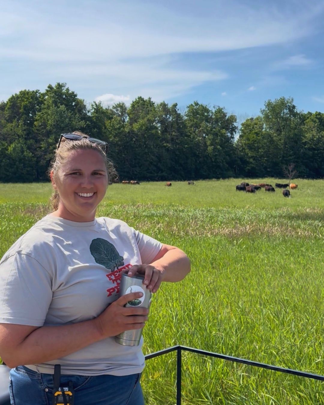 Laurie Pilgram in pasture with cattle grazing in the distance