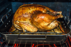 Cooked turkey on roasting pan in oven