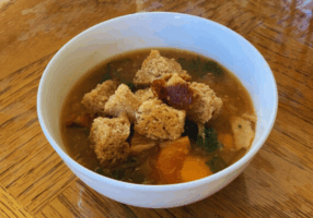 A bowl of Instant Pot Turkey Tuscan Kale Soup topped with homemade Sourdough Croutons
