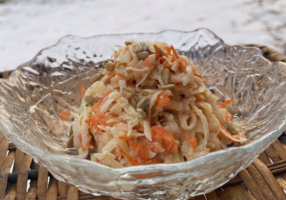 RabiSlaw made with grated kohlrabi, carrots, cabbage, and seeds in a glass bowl