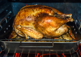 Cooked turkey on roasting pan in oven
